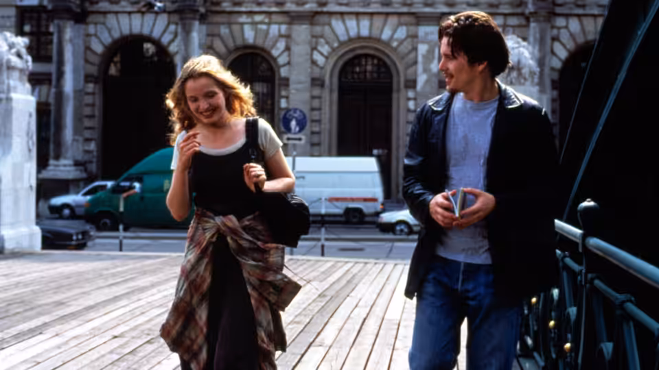 Céline (Julie Delpy) and Jesse (Ethan Hawke) walking on a wooden platform in the city