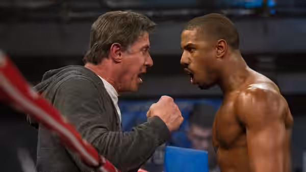 A boxer and his trainer arguing face to face in the ring corner