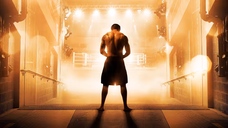 Muscular fighter with back tattoos stands in a hazy boxing arena