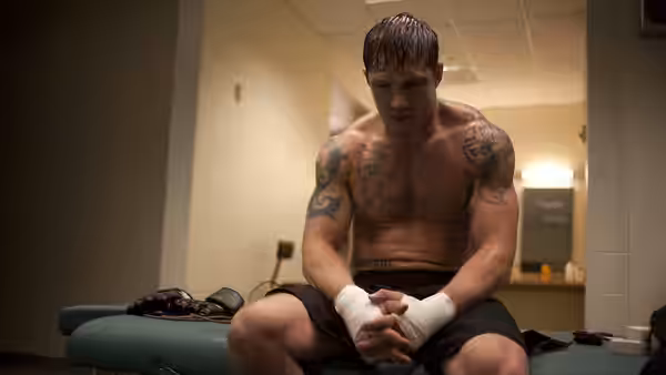 Brendan Conlon (Joel Edgerton) sits on a medical table with bandaged hands