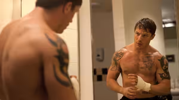 Brendan Conlon (Joel Edgerton) examines his bandaged hand in a locker room mirror