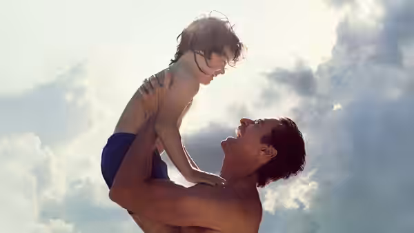 Peter (Hugh Jackman) lifting Nicholas (Zen McGrath) high against the sky