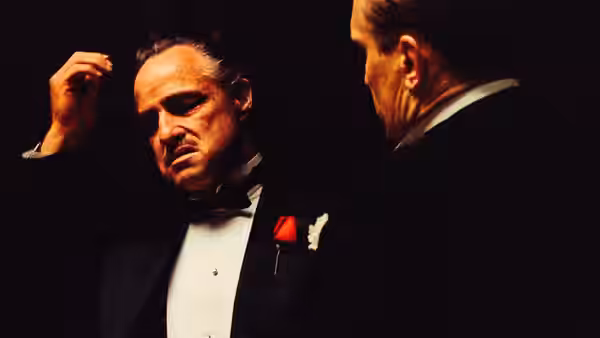 Don Vito Corleone (Marlon Brando) gestures while speaking with another man