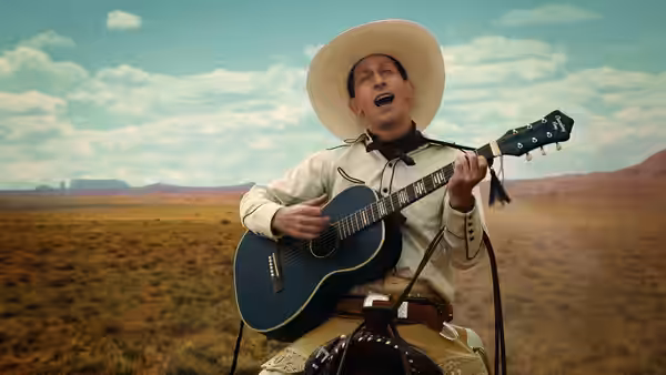 Buster Scruggs (Tim Blake Nelson) singing and playing guitar in the desert