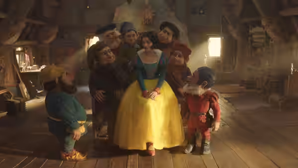 Rachel Zegler as Snow White stands surrounded by seven dwarfs inside a wooden cottage