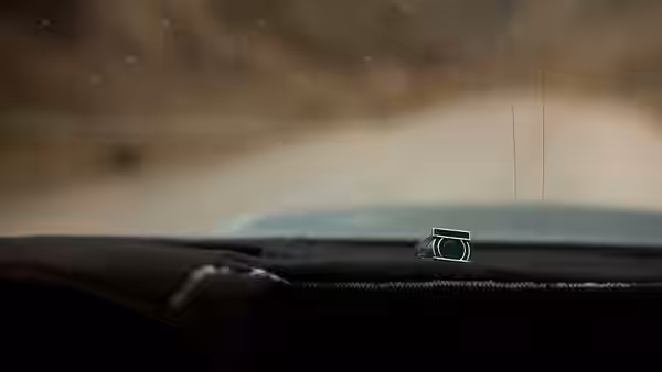 A green power ring rests on the dashboard inside a moving vehicle