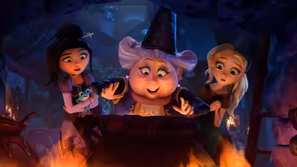 Fairy Godmother (Bette Midler) gestures over a flaming cauldron while Lilith and Cinderella watch
