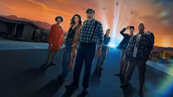 Group of adults standing on a paved road at sunset with mountains behind