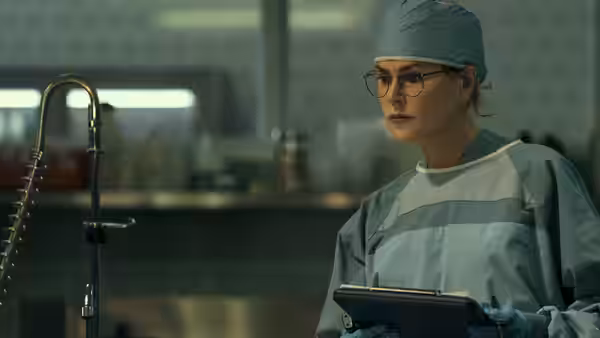 Kay Scarpetta (Nicole Kidman) studying a tablet in surgical scrubs