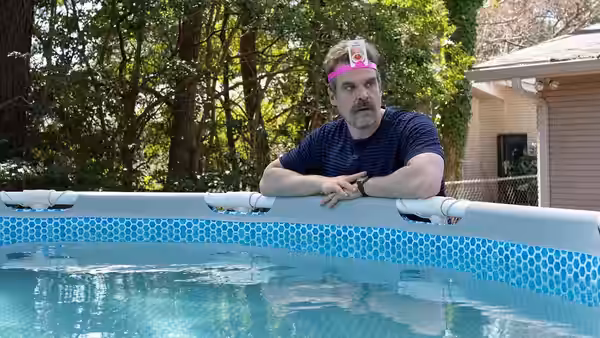 David Harbour leaning on the edge of an above-ground swimming pool