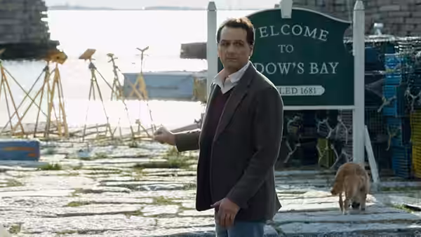Mayor Tom Loftis (Matthew Rhys) gestures near the Widow's Bay welcome sign