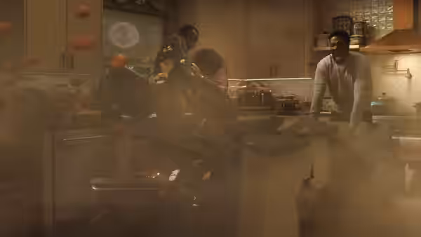 Simon Williams (Yahya Abdul-Mateen II) smiling amid floating food in a kitchen
