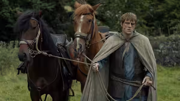 Ser Duncan the Tall (Peter Claffey) leading two horses across a field