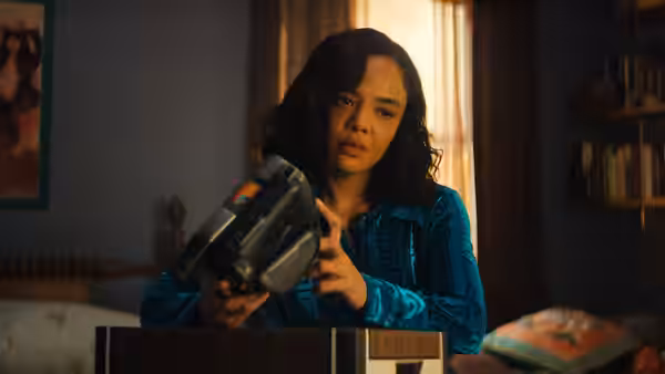 Anna Andrews (Tessa Thompson) holding a large gun in a bedroom