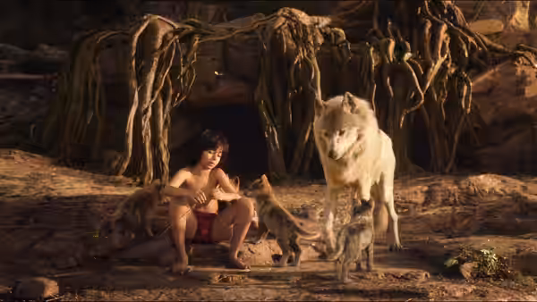 Mowgli (Neel Sethi) sits among wolves outside a root-covered den