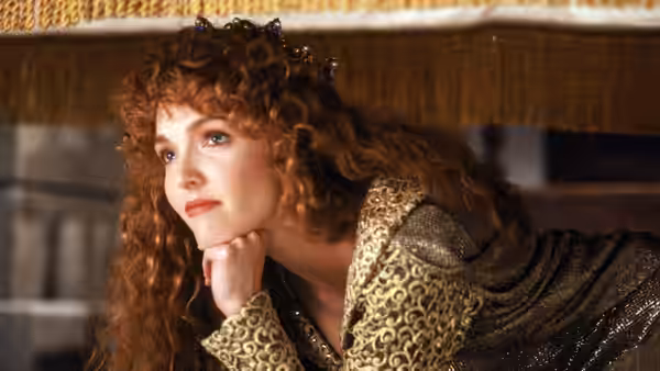 Maid Marian (Amy Yasbeck) rests her chin on her hand wearing a crown