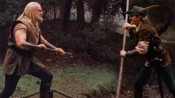 Little John (Eric Allan Kramer) and Robin Hood (Cary Elwes) clash with staffs in the forest