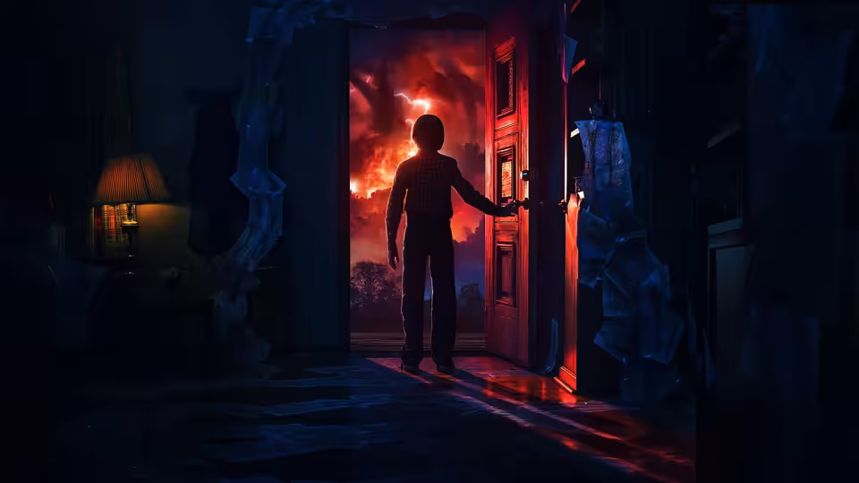 a boy standing in a doorway looking out at a fiery red sky