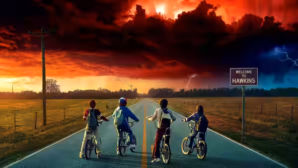 children riding bicycles along a road past a welcome sign