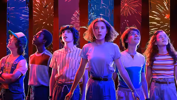 teenagers standing together and looking up at colorful fireworks