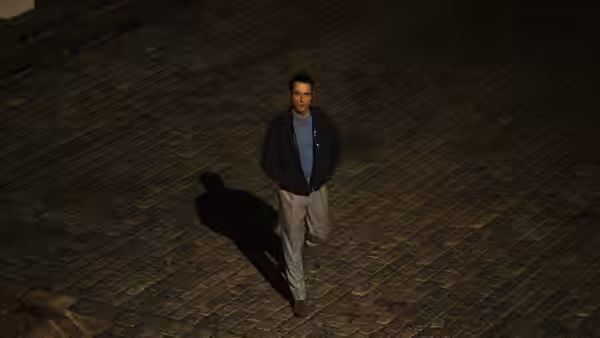 Nile Jarvis (Matthew Rhys) walking on a dimly lit cobblestone street