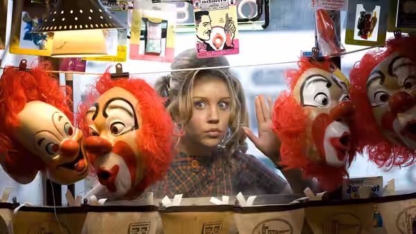 Tracy Turnblad (Nikki Blonsky) looking at clown heads behind a counter