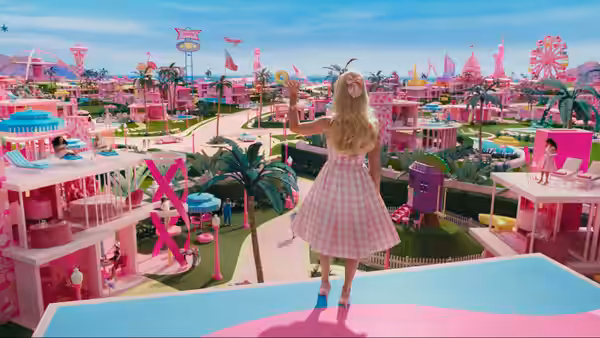 Barbie standing on a balcony overlooking the vibrant pink Barbie Land