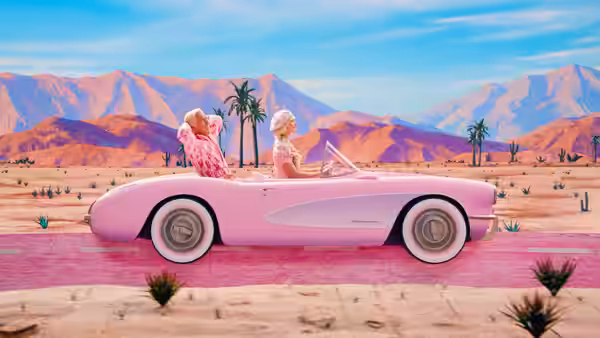 Ken and Barbie driving a pink convertible through a desert landscape