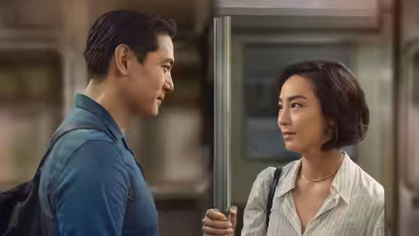 Hae Sung (Teo Yoo) and Nora (Greta Lee) facing each other in a station