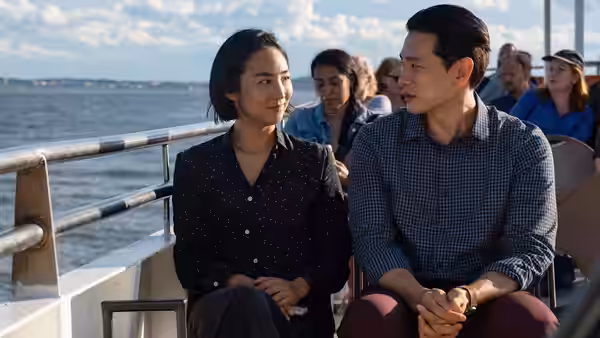 Nora (Greta Lee) and Hae Sung (Teo Yoo) seated on a boat over water