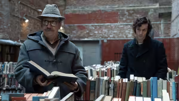 Paul Hunham examining a book in a used bookstore with Angus Tully