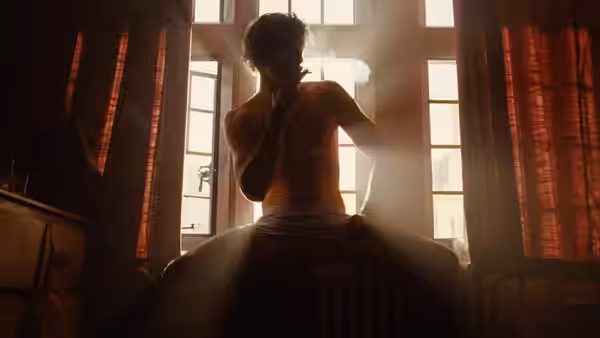 Felix Catton (Jacob Elordi) smoking a cigarette by a sunlit window