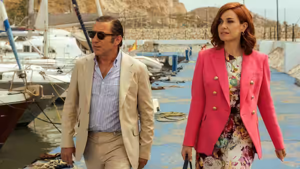 Don Leandro (Antonio de la Torre) and Sofía Carrington (Alexandra Jiménez) walk beside boats at a marina
