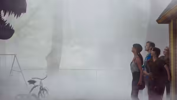 Four people looking upward at a dinosaur head emerging from fog