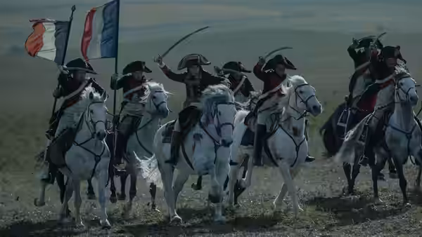 Cavalry officers charging across a field on white horses
