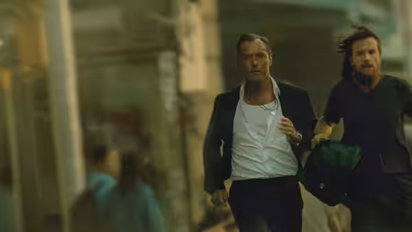 Vince Friedken (Jason Bateman) running beside Jake Friedken (Jude Law) in a station