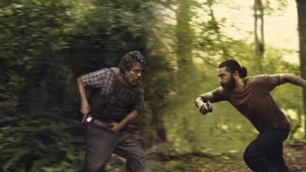 Tom Brandis (Mark Ruffalo) chasing Robbie Prendergrast (Tom Pelphrey) through a forest