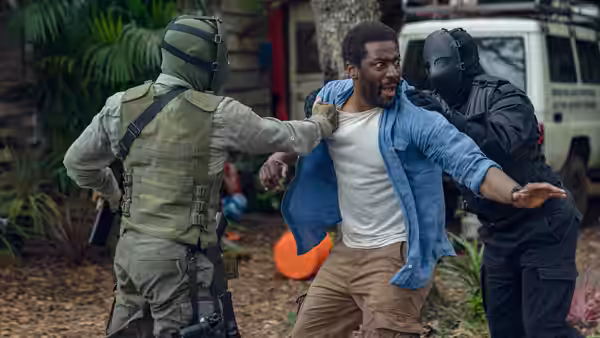 a man being grabbed by two armed officers outside a building