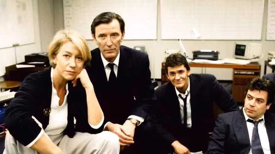 Jane Tennison (Helen Mirren) seated with Bill Otley (Tom Bell) and two men in an office