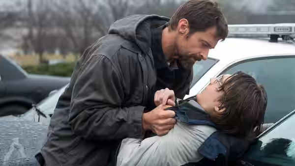 Keller Dover (Hugh Jackman) grabbing Detective Loki (Jake Gyllenhaal) by the collar near a police car