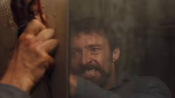 Keller Dover (Hugh Jackman) with bloodied hand pressed against a surface showing anger