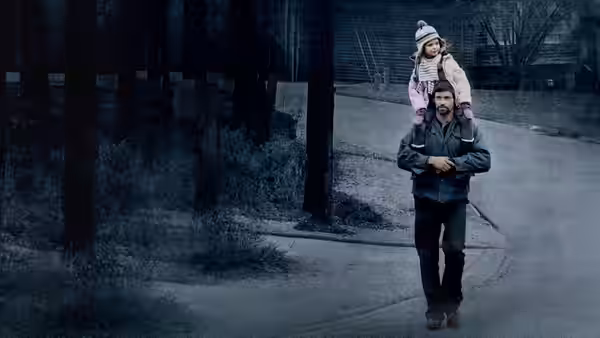 Keller Dover (Hugh Jackman) carrying a young girl on his shoulders down a suburban street