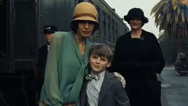 Christine Collins and a boy stand beside a train with another woman