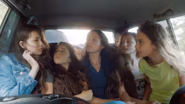 Five girls inside a car with one at the wheel