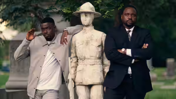 Daniel Kaluuya and Brian Tyree Henry standing by a stone statue