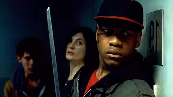 Moses (John Boyega) holds a sword indoors with Sam (Jodie Whittaker) behind him
