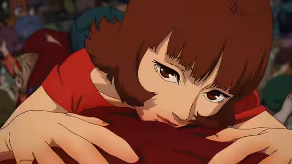 Red-haired woman resting head on red surface with hands