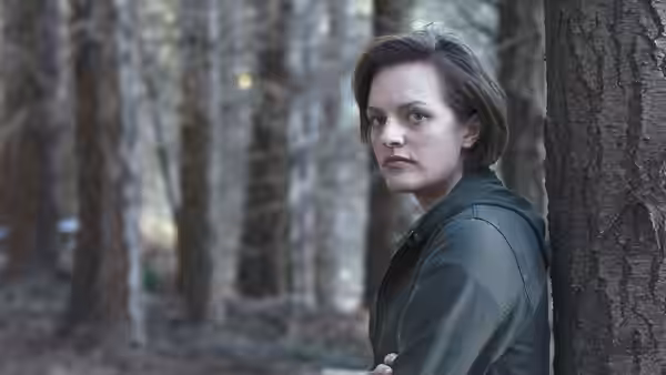 Robin Griffin (Elisabeth Moss) leaning against tree in forest