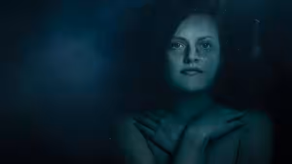 woman with wet hair floating underwater hands crossed over chest