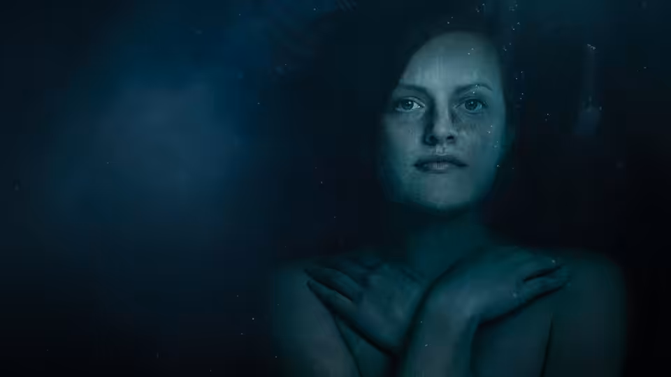 woman with wet hair floating underwater hands crossed over chest